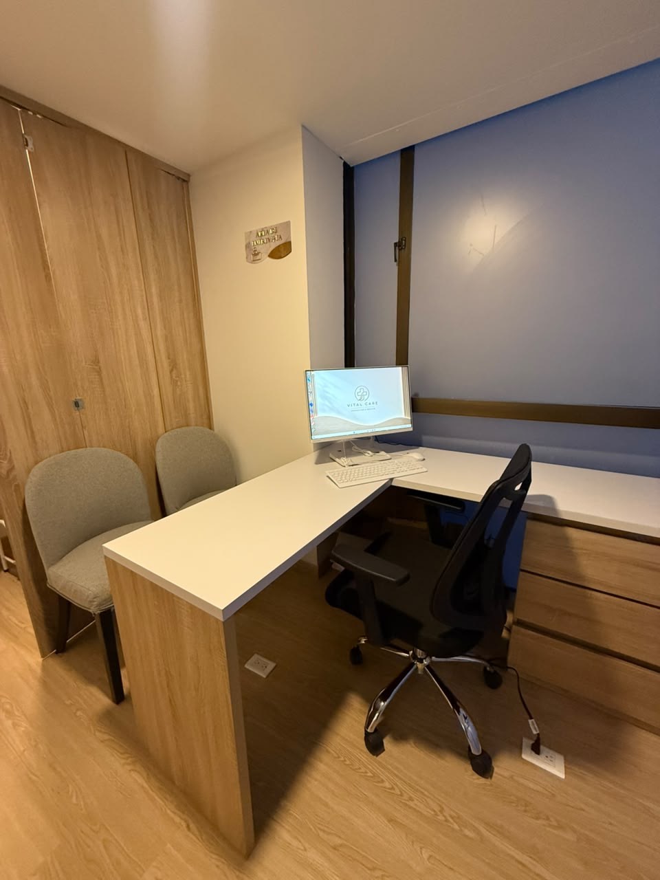 Consultorio médico con escritorio y sillas de atención
