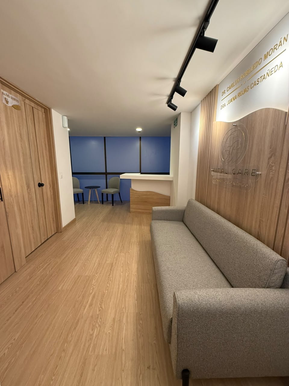 Recepción de Vital Care con sofá y mural de madera